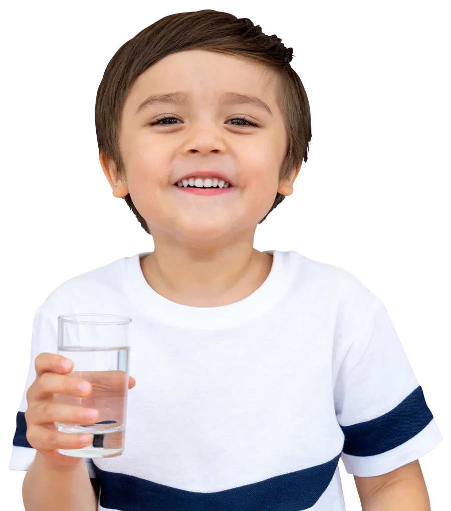 A smiling child holding a glass of filtered water