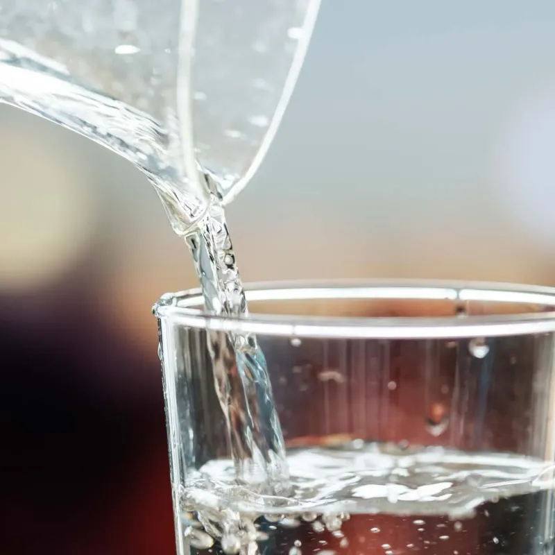 A close-up of clear water pouring into a glass