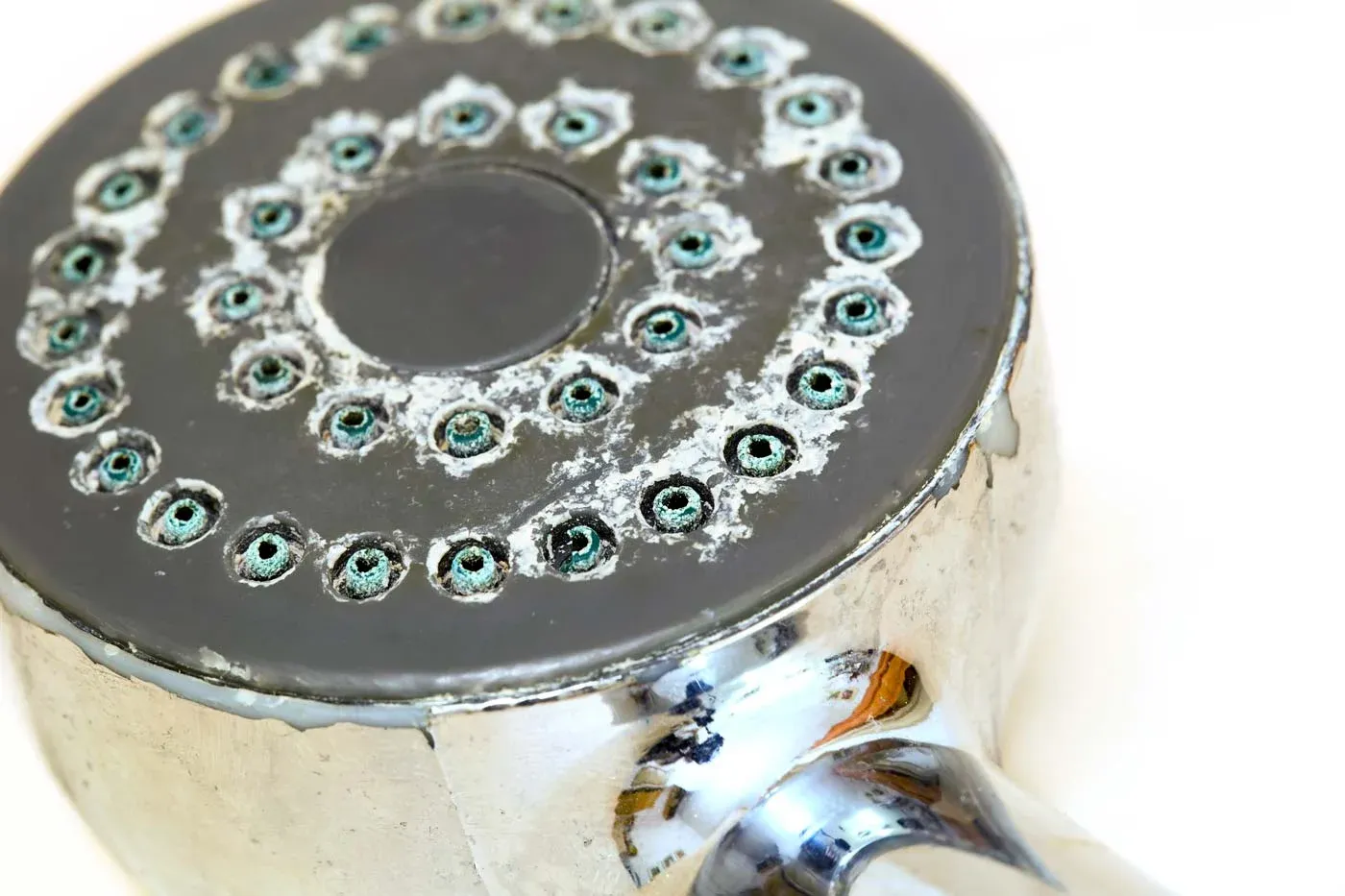 A shower head coated in hard-water lime scale